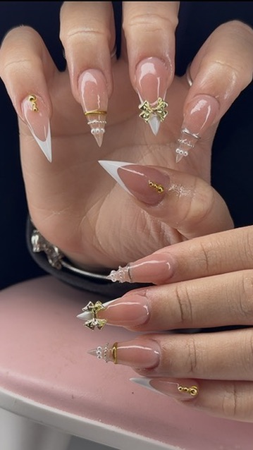 White French stiletto nails with gold charms