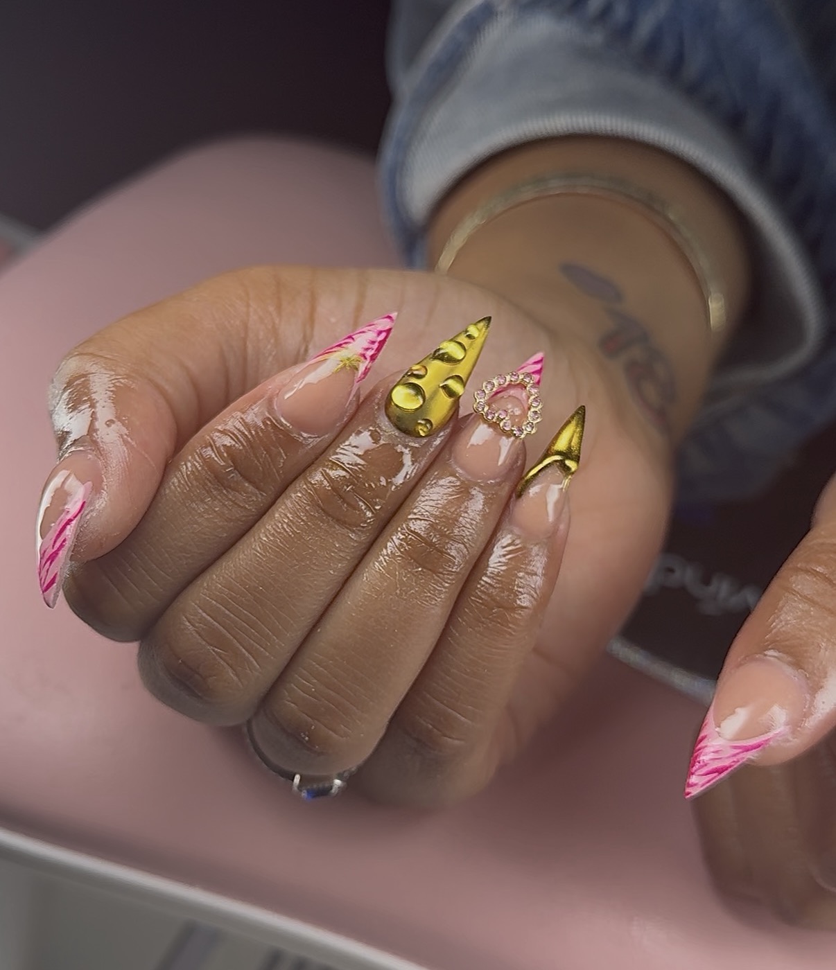 Pink stiletto nails with gold sculpted accents