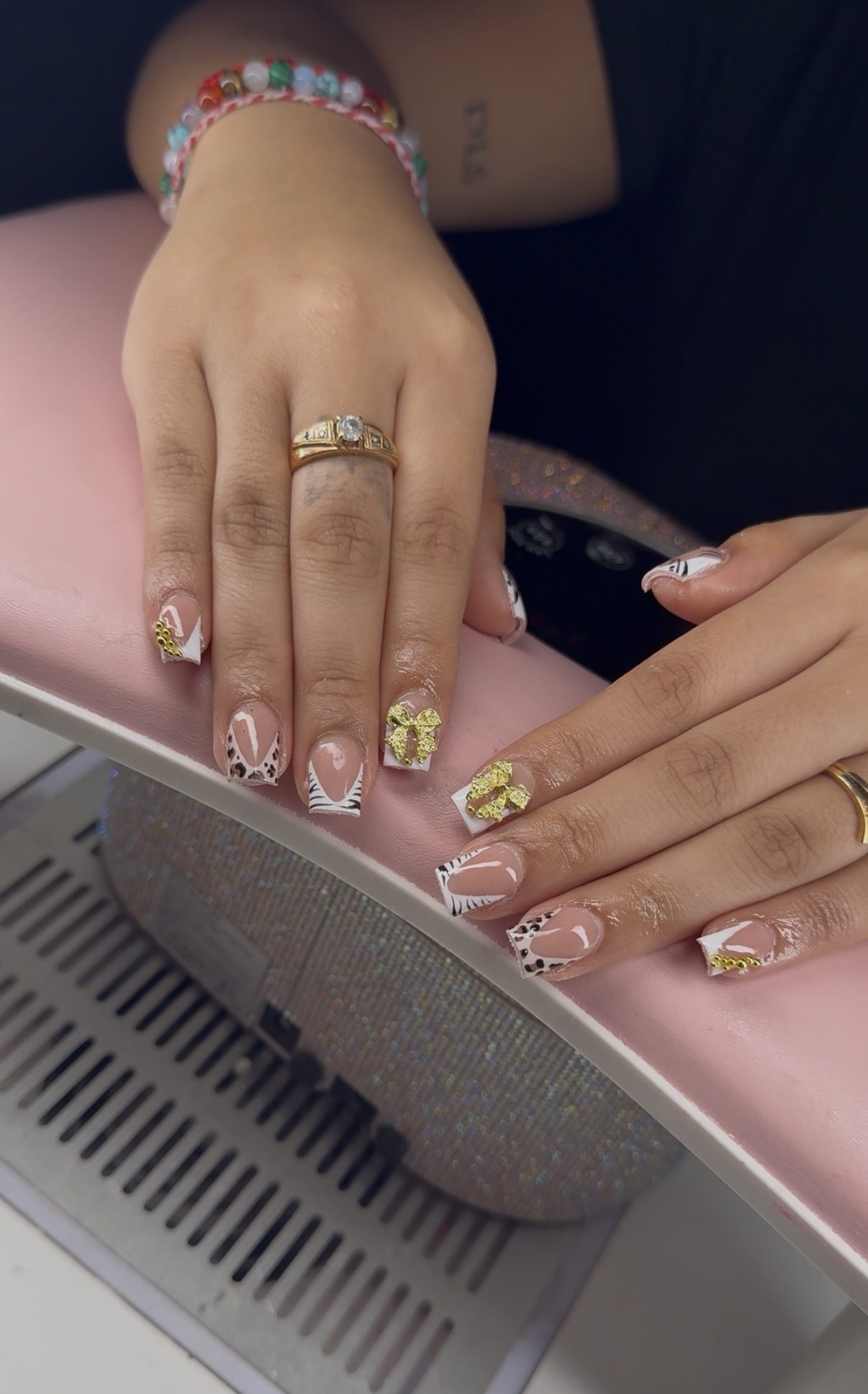 Square nails with animal print French tips and gold bow accents