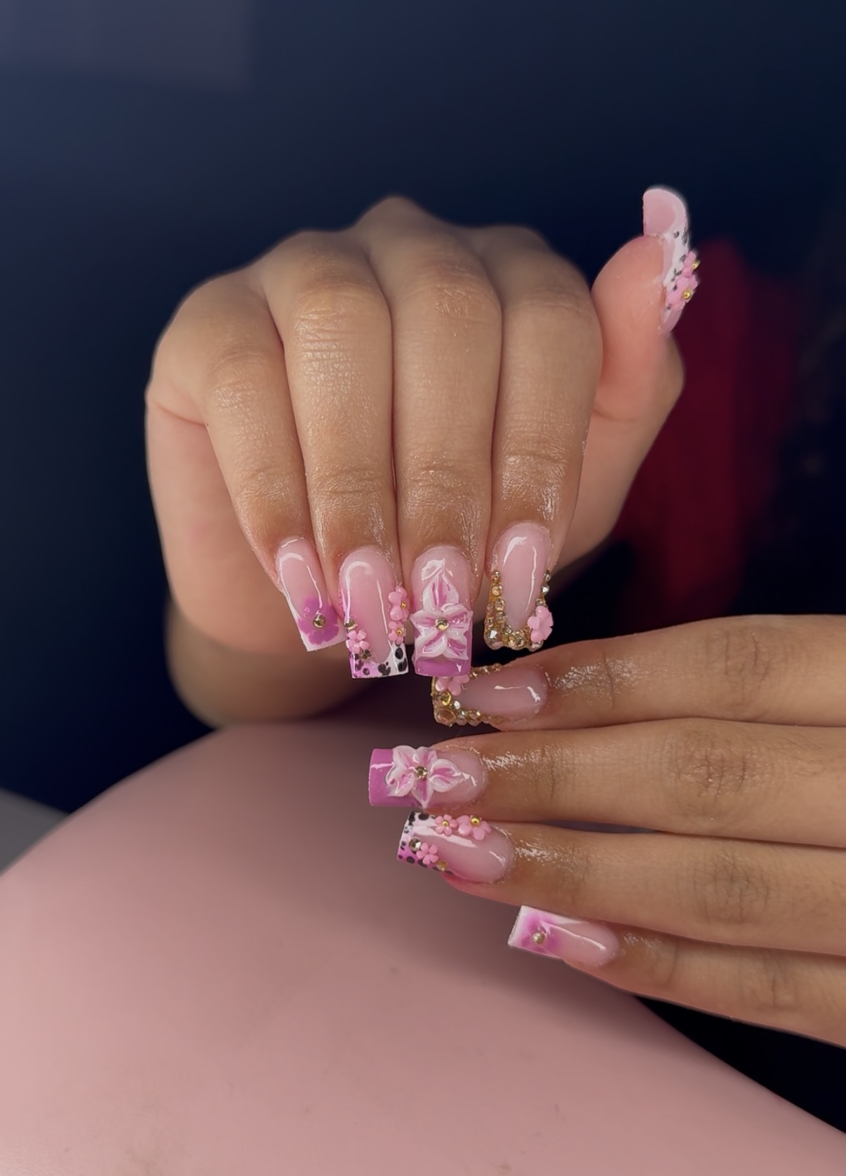 Pink floral nail set with gold accents and charms