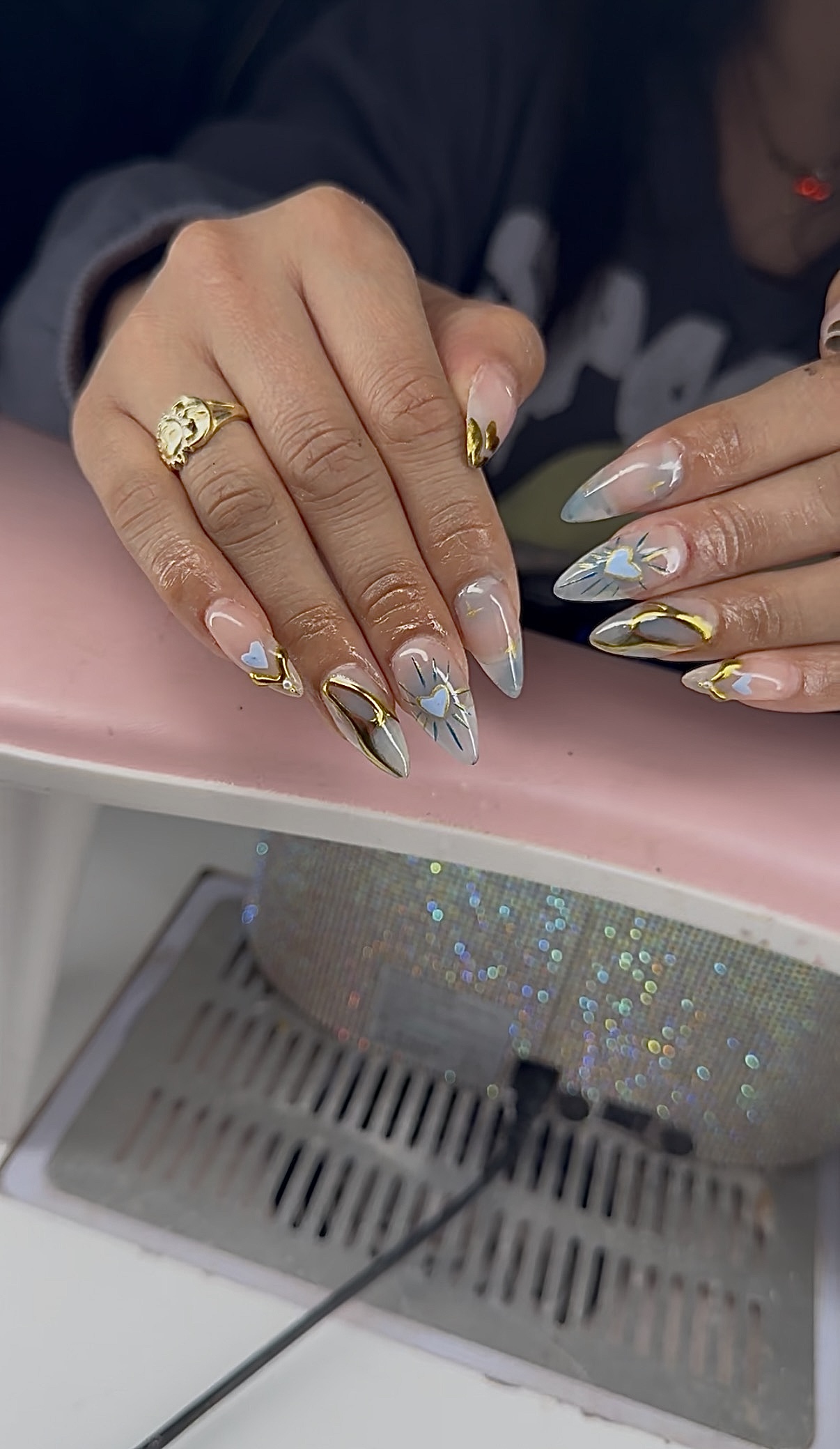 Silver chrome stiletto nails with gold accents and heart details